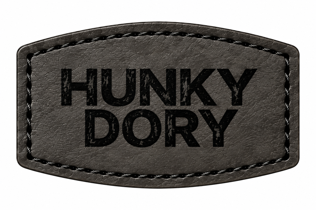 A black patch with stitched borders and the text 'HUNKY DORY' printed in black distressed lettering, shown on a plain white background.