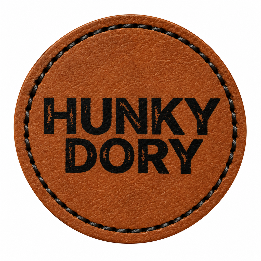 A round brown patch with black stitched border and the text 'HUNKY DORY' printed in black capital letters, shown on a plain white background.