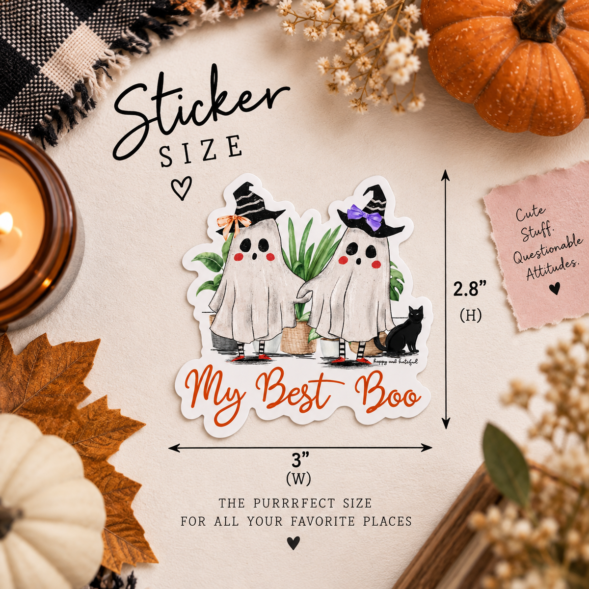A Halloween-themed sticker featuring two cute cartoon ghosts wearing witch hats, with the text 'My Best Boo' below them. The sticker is shown on a styled flat-lay background with autumn props, including pumpkins, leaves, a candle, and a note card.